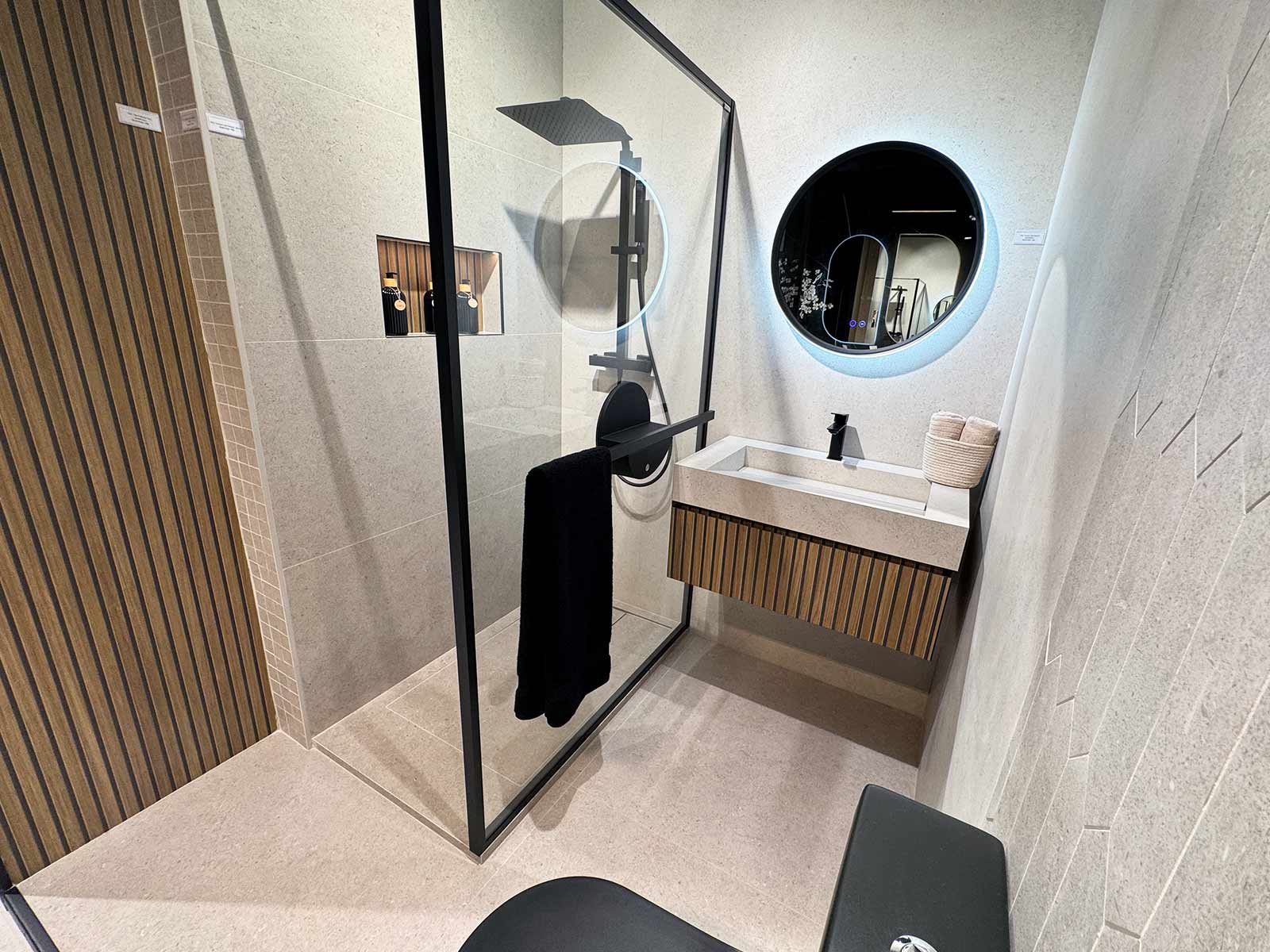 Baño con revestimiento color arena y mueble de madera